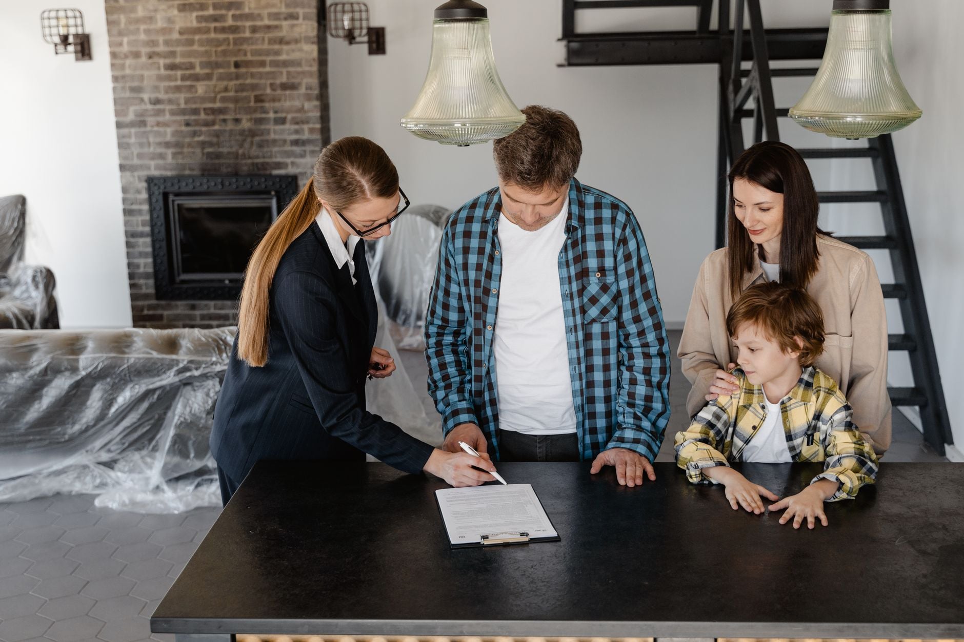 A family sits together on a couch in their new home, embracing the moving experience.